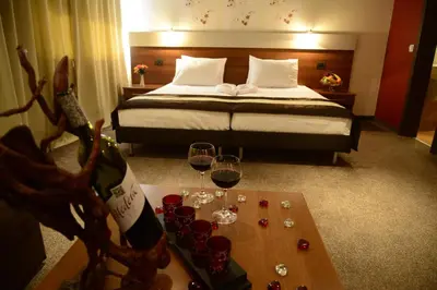 a hotel room with a bed and a table with wine glasses at Hotel Forum - Free Parking for cars in Sofia