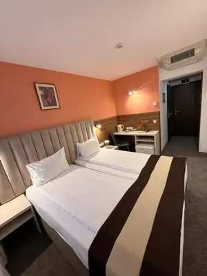 a hotel room with a large bed and a desk at Hotel Forum - Free Parking for cars in Sofia