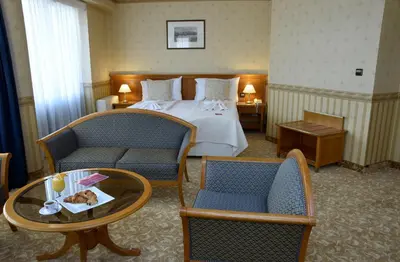 a hotel room with a bed and two chairs and a table at Hotel Downtown in Sofia