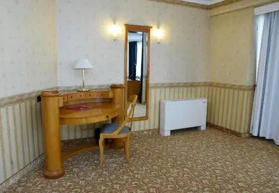 a room with a desk and a chair and a mirror at Hotel Downtown in Sofia