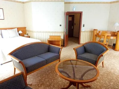 a bedroom with a bed and two chairs and a table at Hotel Downtown in Sofia