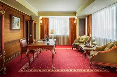 a hotel room with a table and a chair and a couch at Grand Hotel Sofia in Sofia