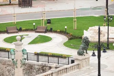 a statue in a park next to a park with benches at Hotel Lion Sofia in Sofia