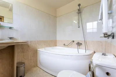 a bathroom with a tub and a toilet and a sink at Hotel Brod - Free Parking in Sofia