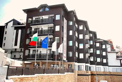 a tall building with flags in front of it at Royal Park Spa Bansko, private apartments within the complex in Bansko