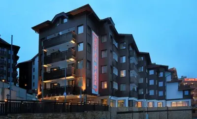 a building with a sign on the side of it at Royal Park Spa Bansko, private apartments within the complex in Bansko