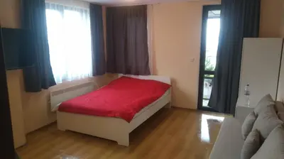 a bedroom with a bed with a red blanket at Royal Park Spa Bansko, private apartments within the complex in Bansko
