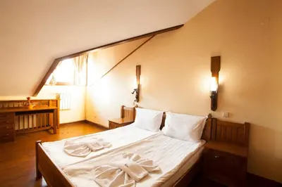 a bedroom with a bed with two towels on it at Hotel Tanne in Bansko
