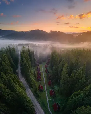 an aerial view of a foggy forest with a road at Complex Malina Pamporovo in Pamporovo