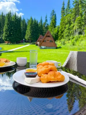 a table with a plate of food on a table with a table at Complex Malina Pamporovo in Pamporovo