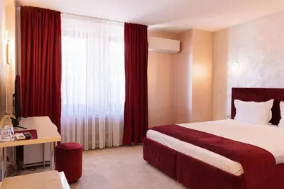 a hotel room with a bed and a window at Hotel Dafi in Plovdiv