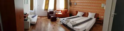 a hotel room with two beds and a chair at Scotty's Boutique Hotel in Sofia