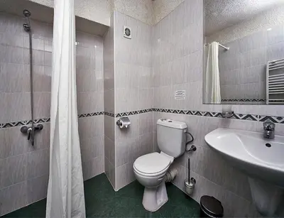 a bathroom with a toilet and a sink at Hotel Akord - Free Parking & Metro Access in Sofia