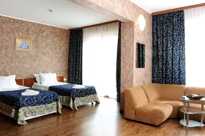 a hotel room with a bed and a couch at Hotel Akord - Free Parking & Metro Access in Sofia
