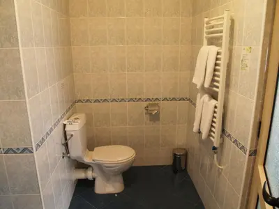 a bathroom with a white toilet in a room at Hotel Akord - Free Parking & Metro Access in Sofia