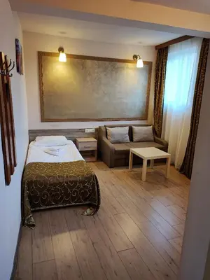 a hotel room with a bed and a couch at Hotel Akord - Free Parking & Metro Access in Sofia