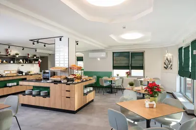 a restaurant with tables and chairs and a cafeteria at Jasmin Hotel in Sofia