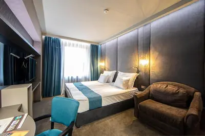 a hotel room with a bed and a chair at Spa Hotel Ezeretz Blagoevgrad in Blagoevgrad