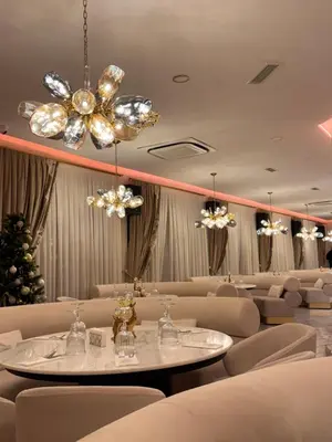 a dining room with chairs and a table and chandeliers at Spa Hotel Ezeretz Blagoevgrad in Blagoevgrad