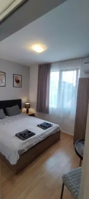 a bedroom with a large bed and a window at Benita Inn apartments in Sofia