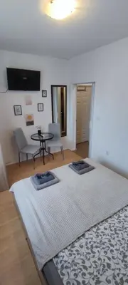 a large bed in a room with a table and chairs at Benita Inn apartments in Sofia