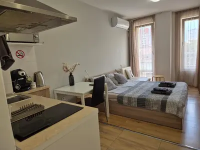 a bedroom with a bed and a kitchen with a stove at Benita Inn apartments in Sofia