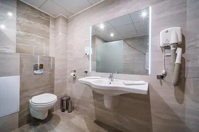 a bathroom with a sink and a toilet and a mirror at Hotel Avion - Self check in in Plovdiv