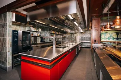 a large kitchen with red cabinets in a restaurant at Kempinski Hotel Grand Arena Bansko in Bansko