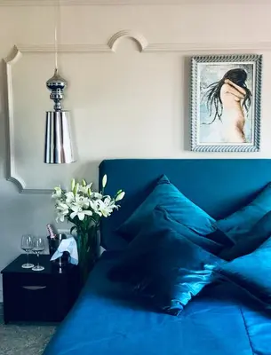 a bedroom with a blue bed and a vase of flowers at Atlantic Hotel - Free Parking in Sofia
