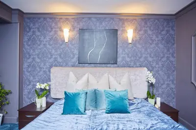 a bedroom with a bed with blue walls at Atlantic Hotel - Free Parking in Sofia