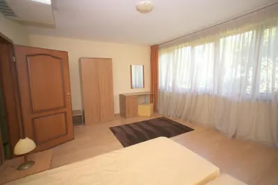a bedroom with a bed and a window and a door at Hotel Gloria Palace Diplomat in Sofia