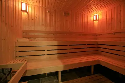 a sauna with a bench and lights in it at Perun Hotel Sandanski in Sandanski