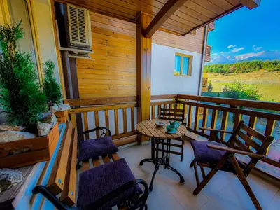 a porch with a table and chairs on a balcony at St. John Hill Bansko in Bansko