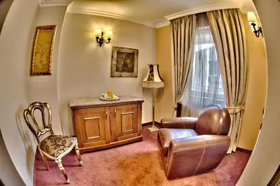 a living room with a couch and a chair and a table at Meg-Lozenetz Hotel in Sofia