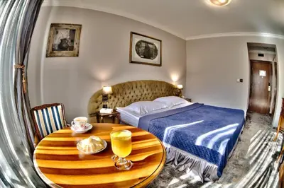 a bedroom with a bed and a wooden table at Meg-Lozenetz Hotel in Sofia