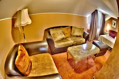a living room with a couch and a table at Meg-Lozenetz Hotel in Sofia