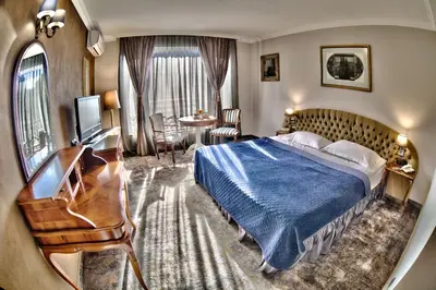 a hotel room with a bed and a desk at Meg-Lozenetz Hotel in Sofia
