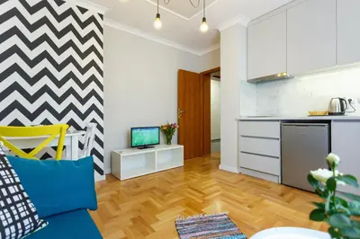 a kitchen and a living room with a couch and a tv at Dunav Apartment House in Sofia