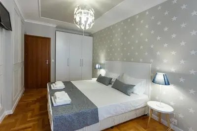 a bedroom with a large white bed with stars on the wall at Dunav Apartment House in Sofia