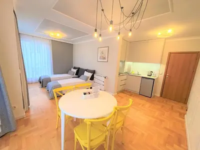 a living room with a table and yellow chairs at Dunav Apartment House in Sofia