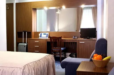 a hotel room with a desk with a computer and a chair at DITER Family Hotel in Sofia