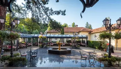 a courtyard with a fountain and tables and chairs at Spa Hotel Rich in Velingrad