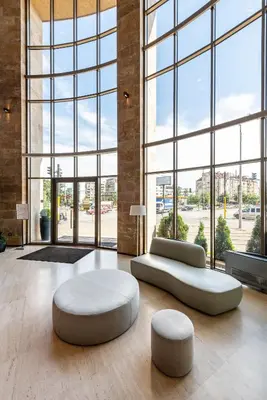 a large room with two couches and two ottomans at Hotel VEGA Sofia in Sofia