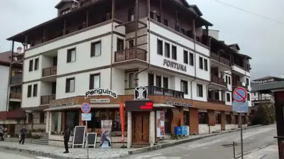 a large white building on the side of a street at Fortuna Luxury Apartment in Bansko