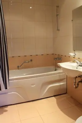 a bathroom with a bath tub and a sink at Fortuna Luxury Apartment in Bansko