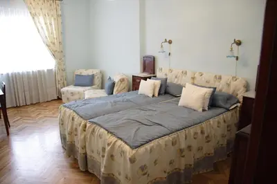 a large bed in a room with a couch and chairs at Casa Ferrari Bed & Breakfast in Sofia
