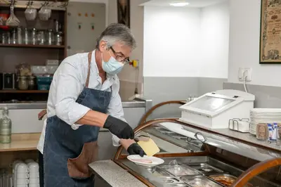 a man in a kitchen preparing food on a plate at Hotel Niky in Sofia