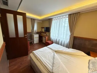 a hotel room with a bed and a desk at California Hotel in Sofia