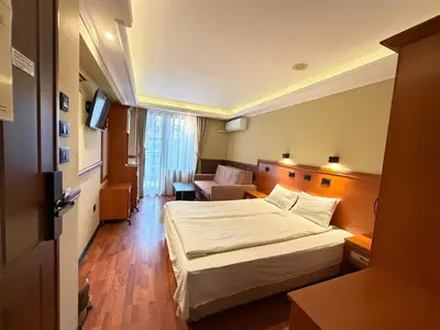 a hotel room with a bed and a couch at California Hotel in Sofia