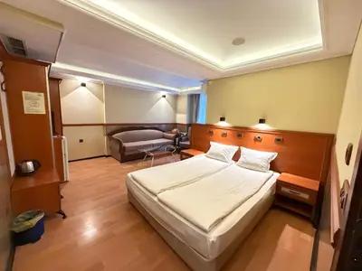 a hotel room with a bed and a couch at California Hotel in Sofia
